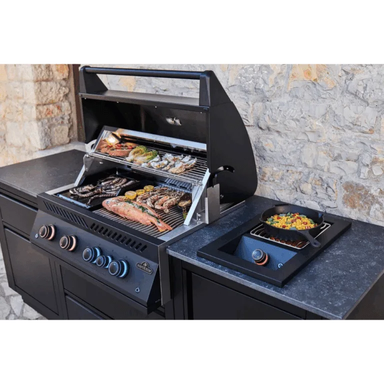 Napoleon Outdoor Kitchen Oasis compact 105 for outdoor cooking. BBQ grill head and side burner in Matt black with food.