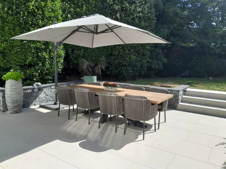 Los marcos Timor teak garden dining table with Alexander light grey parasol and bernini rope chairs.