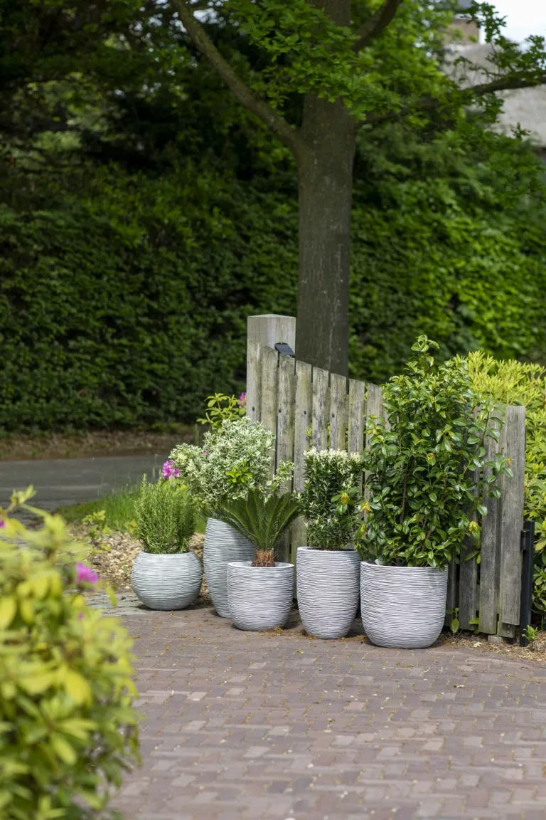 Capi Various natural round base pots in an outdoor garden setting