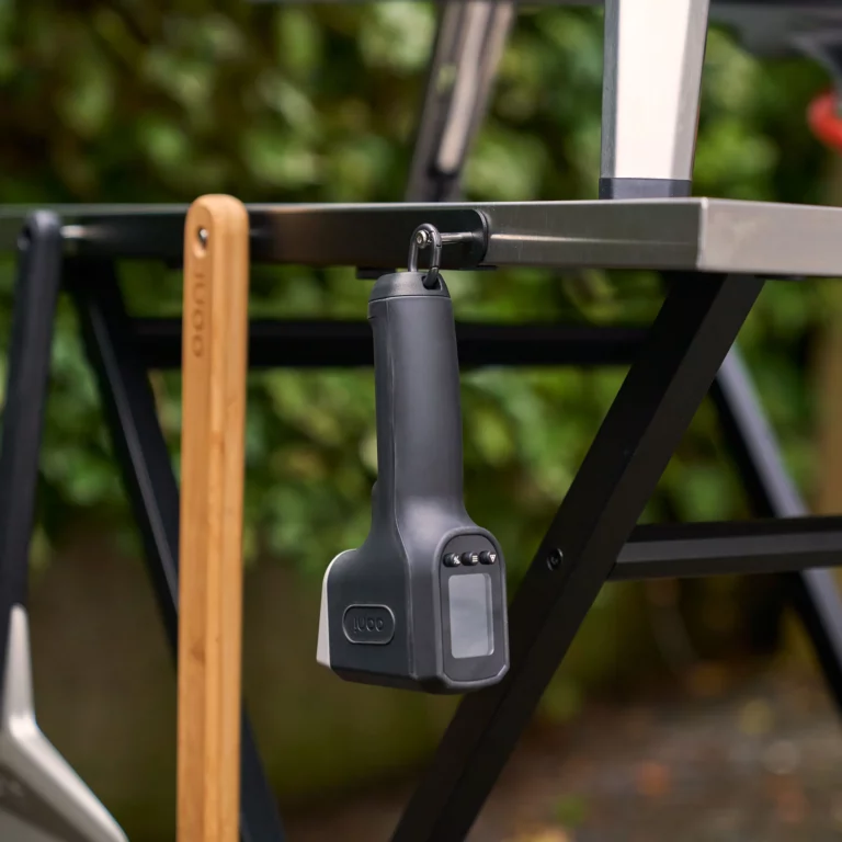 Ooni Infrared Thermometer hanging by the hook on the Ooni Modular Table