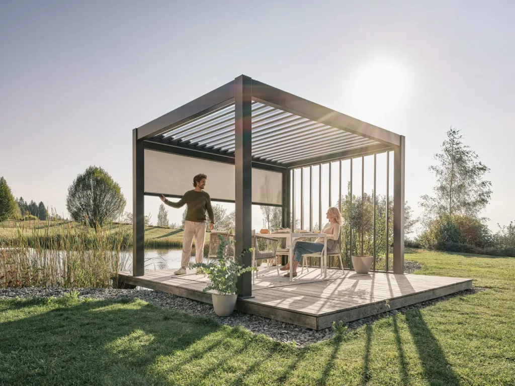 Customer enjoying Biohort pergola in their garden with Blinds and shade from sun.