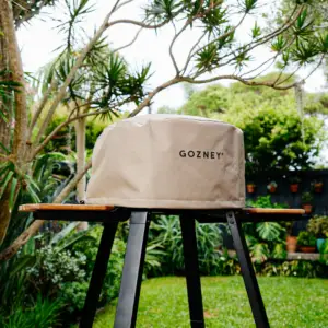 Weatherproof cover protecting an outdoor pizza oven